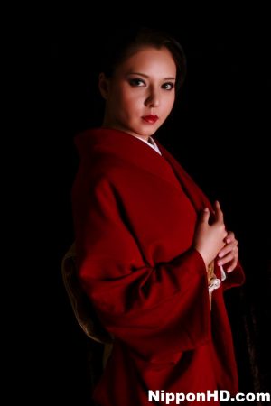 Japanese woman sports red lips while producing a knife in traditional clothing
