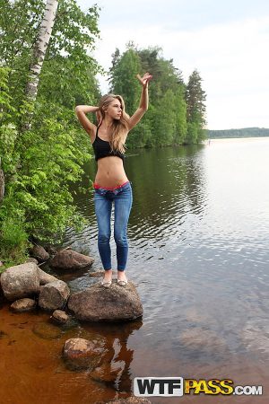 Girl next door Megan pulls out her tits while sitting on a rock in the lake