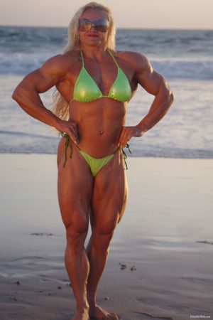 Muscular blonde MILF in sunglasses Brigita Brezovac poses in a green bikini