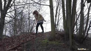 Caucasian girl takes a piss in an outhouse while in a forest