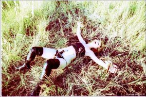 Latex clad chick is tied up and masturbated in long grass at old brick factory