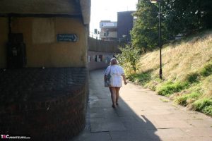 Fat older nurse Lexie Cummings exposes herself while walking on a sidewalk