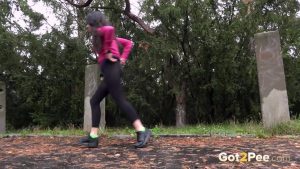Dark haired girl Goldie pulls down black leggings to pee next to the woods